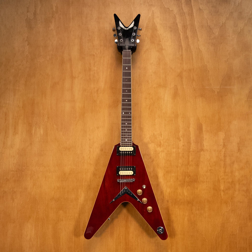 Dean 79 V electric guitar in transparent cherry finish, with double-cutaway body and chrome hardware, shown in a close-up shot.
