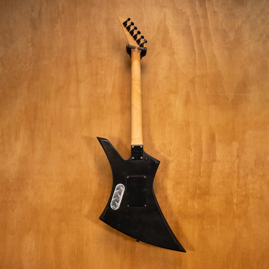 Preloved Jackson Kelly electric guitar with EMG pickups, featuring a sleek body and modern hardware, displayed in a well-lit setting.