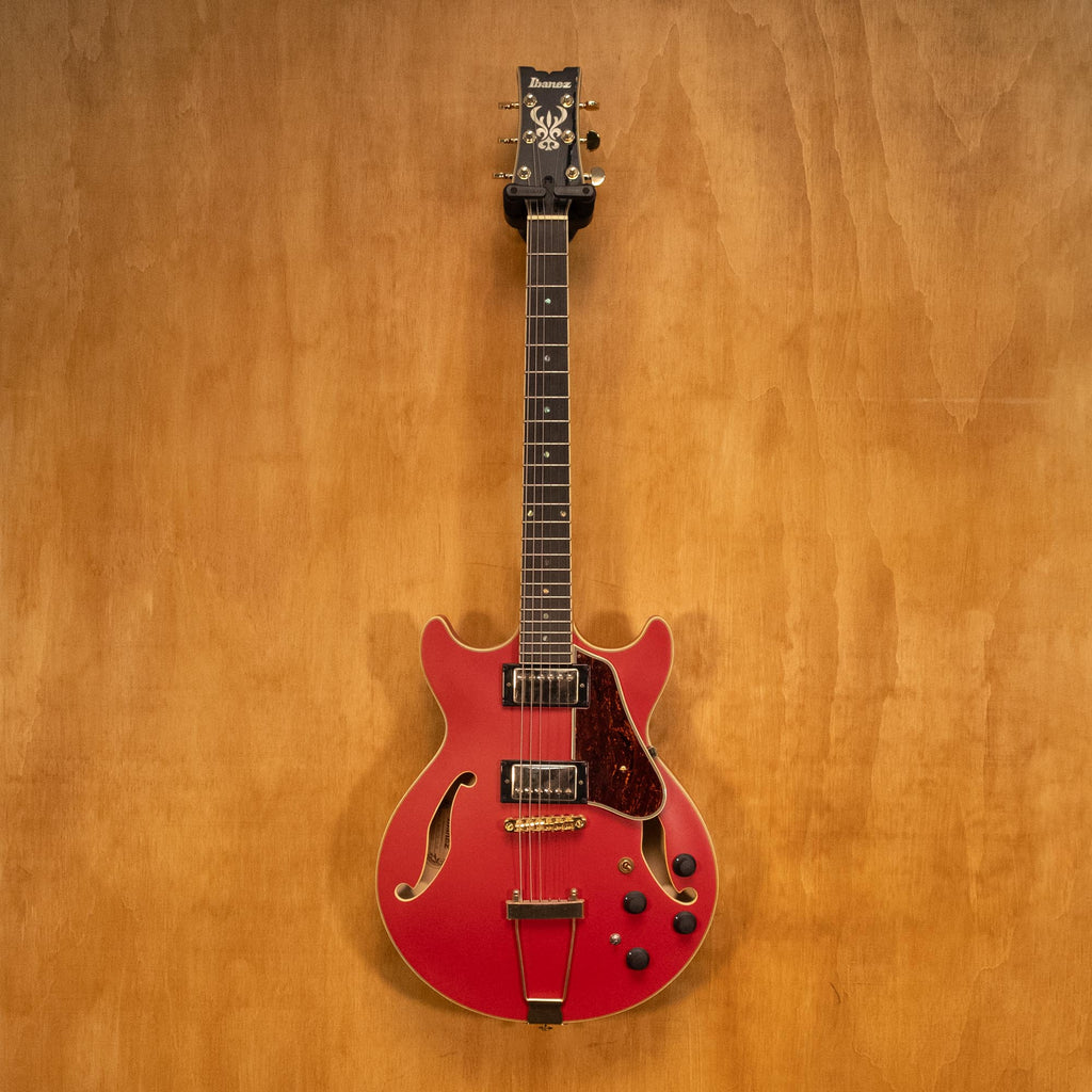 Ibanez AMH90 hollow body electric guitar in cherry red flat finish, showcasing the guitar's body and hardware details.