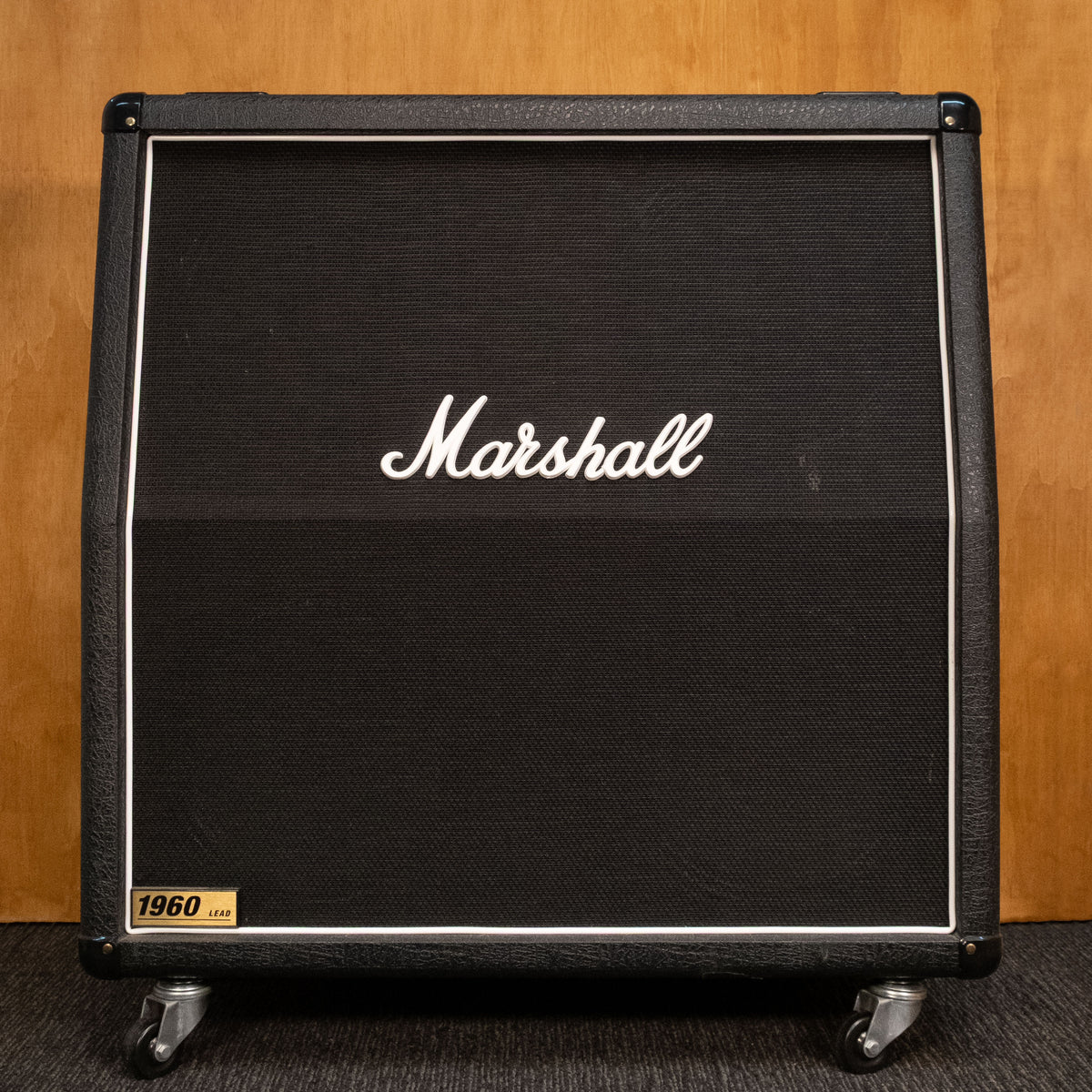 Marshall 1960A 4x12 guitar amplifier cabinet with vintage speaker grill and rugged wood finish, used but well-maintained.