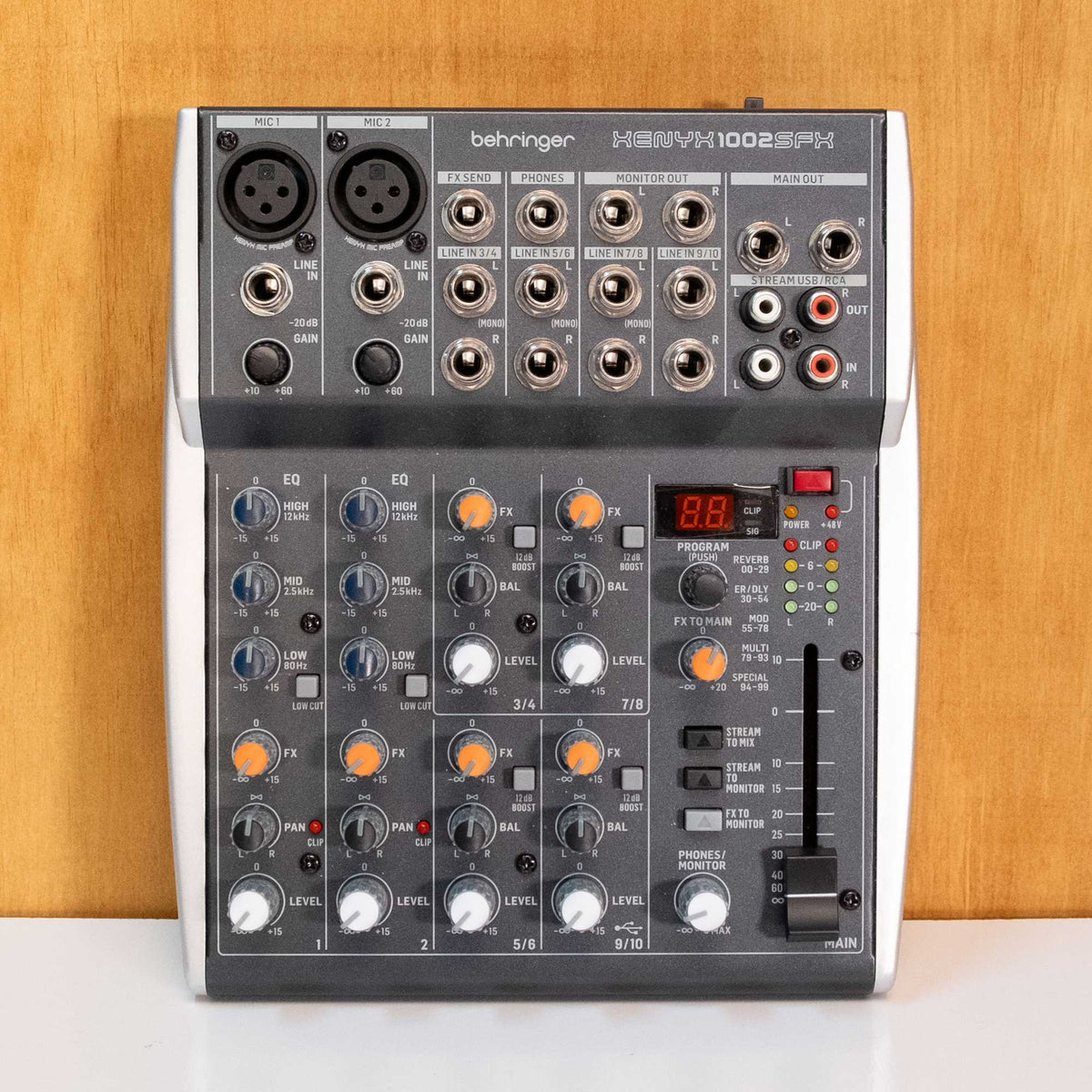 Behringer Xenyx 1002SFX analogue mixer with multiple input channels and control knobs, used for audio mixing.