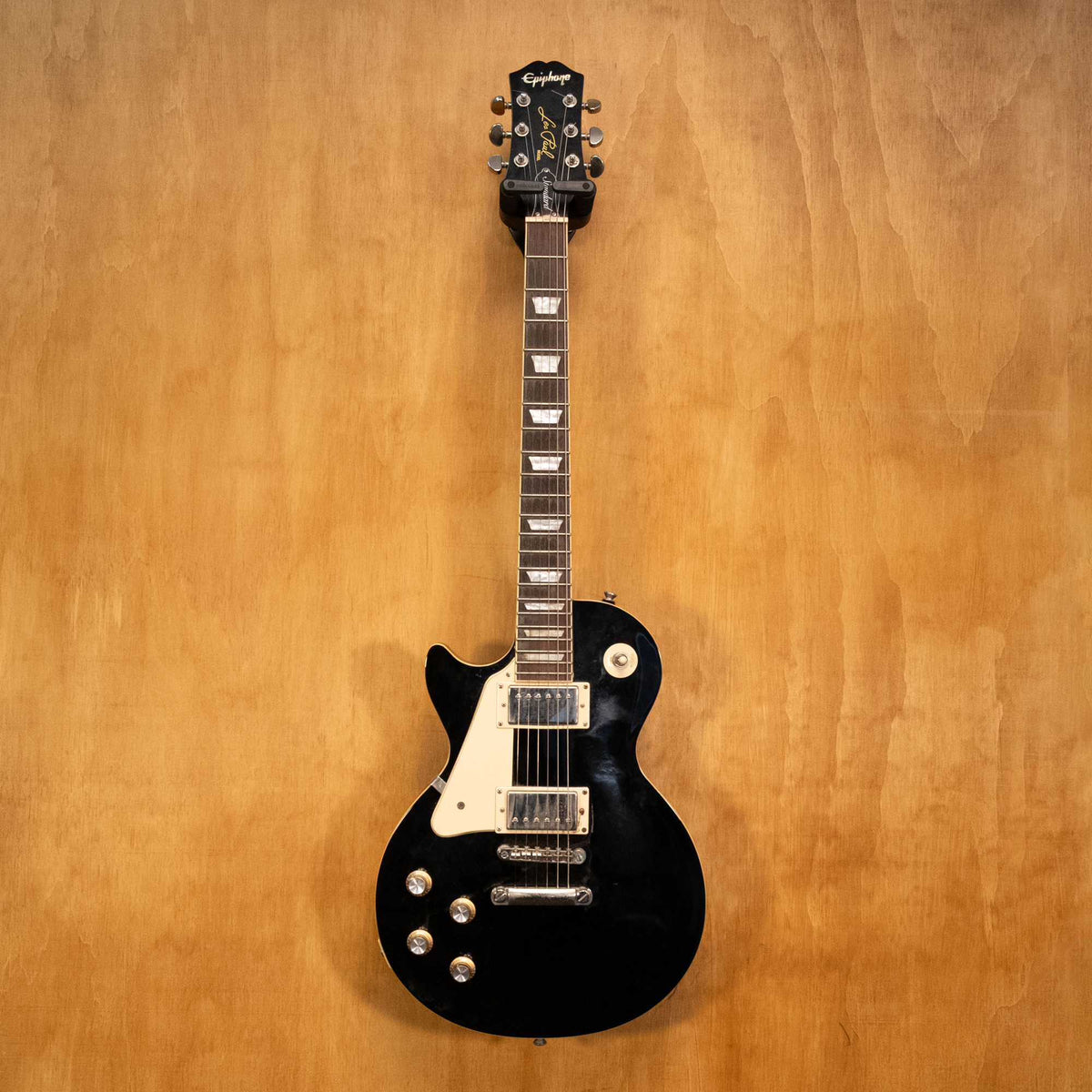 Left-handed Epiphone Les Paul electric guitar in ebony finish, showcasing the body, pickups, and neck detail.