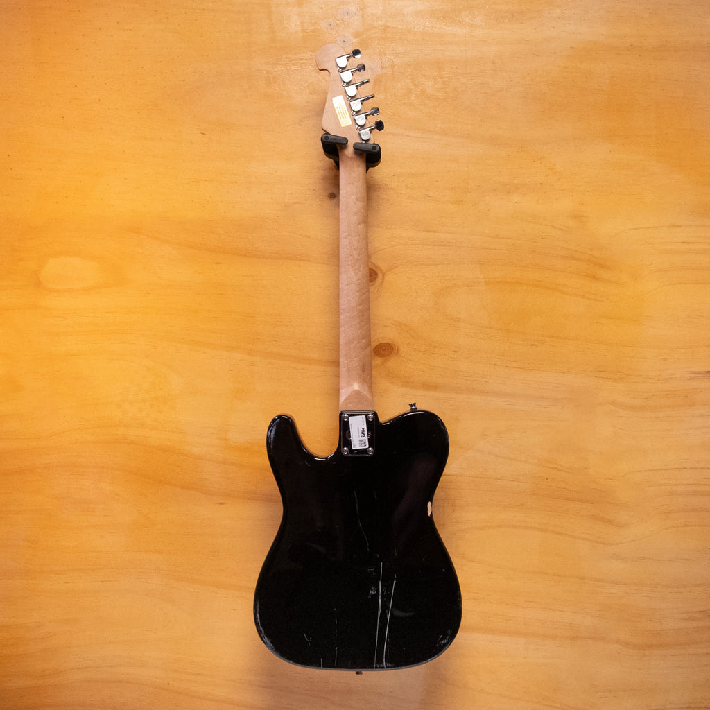 Preloved SX T-style electric guitar in black, showcasing its sleek body and classic design details.