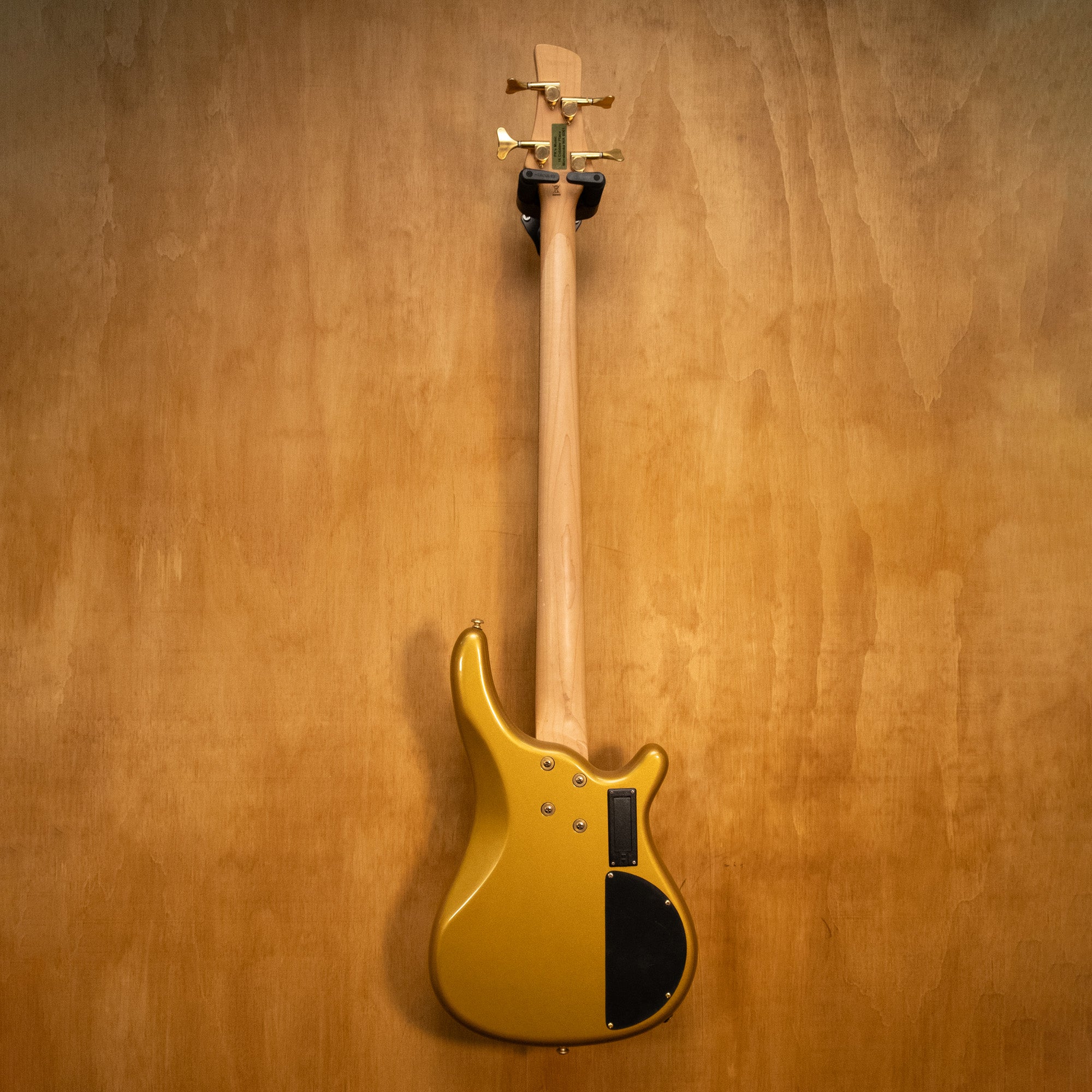 Left-handed J&D Luthiers active bass guitar in gold finish, showcasing its sleek design and craftsmanship.