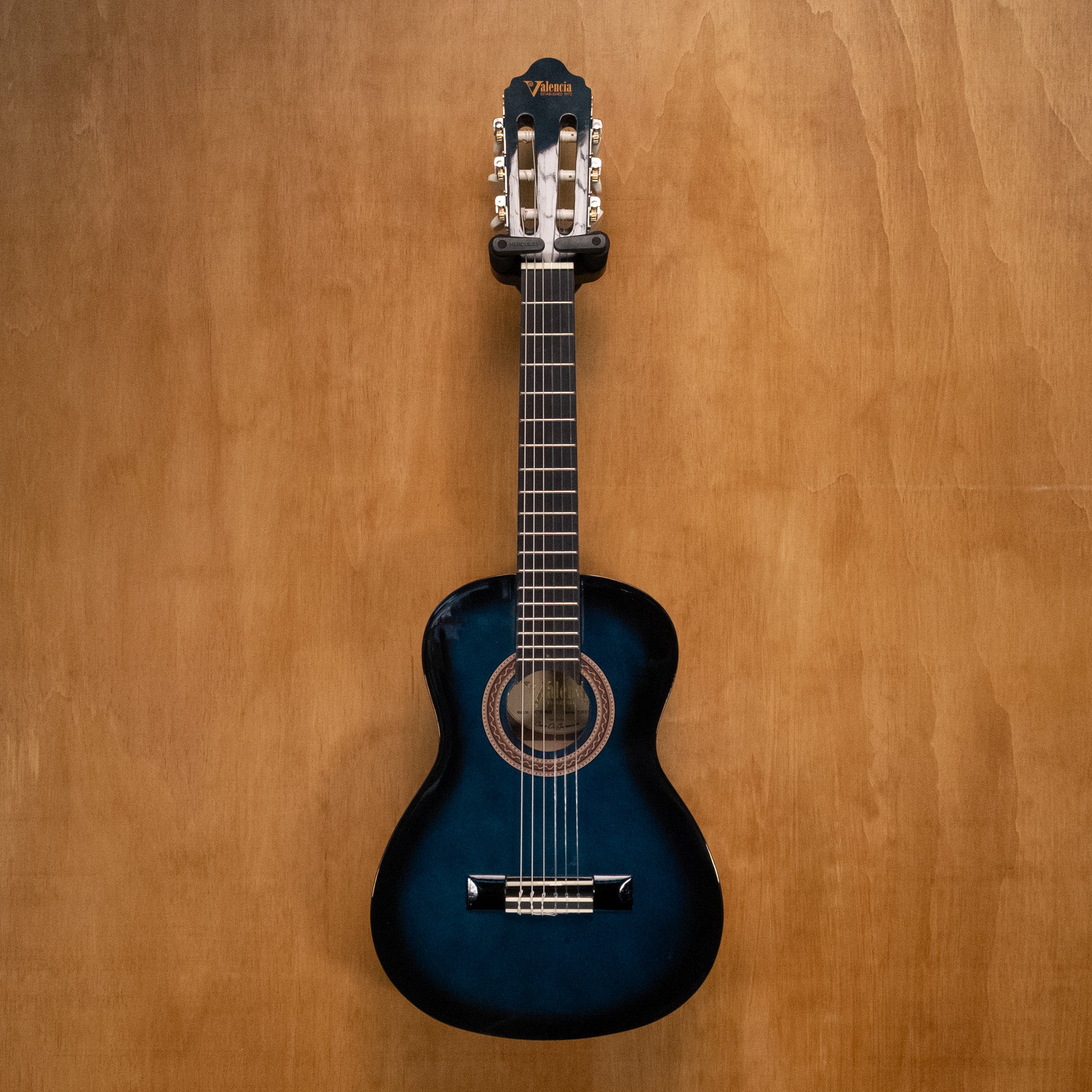 Valencia VC101 1/4 classical guitar in blue sunburst finish, showing the body, strings, and fretboard detail.