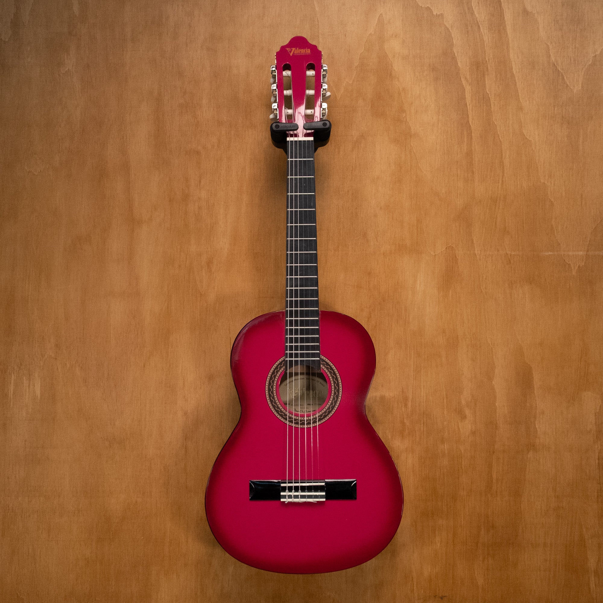 Valencia VC102 1/2 classical guitar in pink sunburst finish, showing the body, neck, and strings on a plain background.