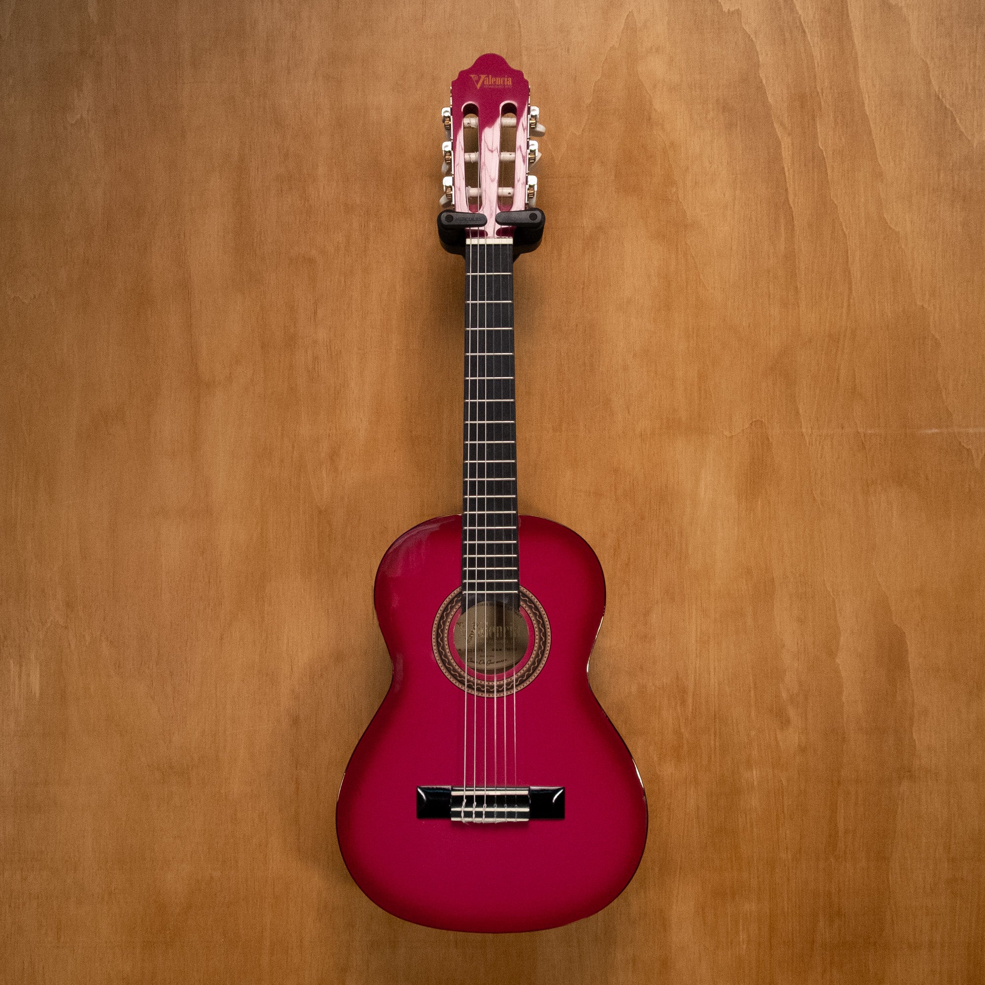 Valencia VC101 1/4 classical guitar in pink sunburst finish, preowned, with nylon strings and a wooden body.