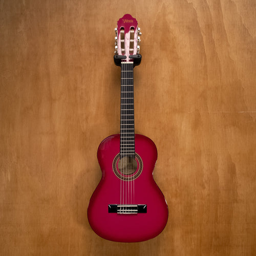 Preloved Valencia VC101 1/4 classical guitar in pink sunburst finish, showing the body, strings, and fretboard.