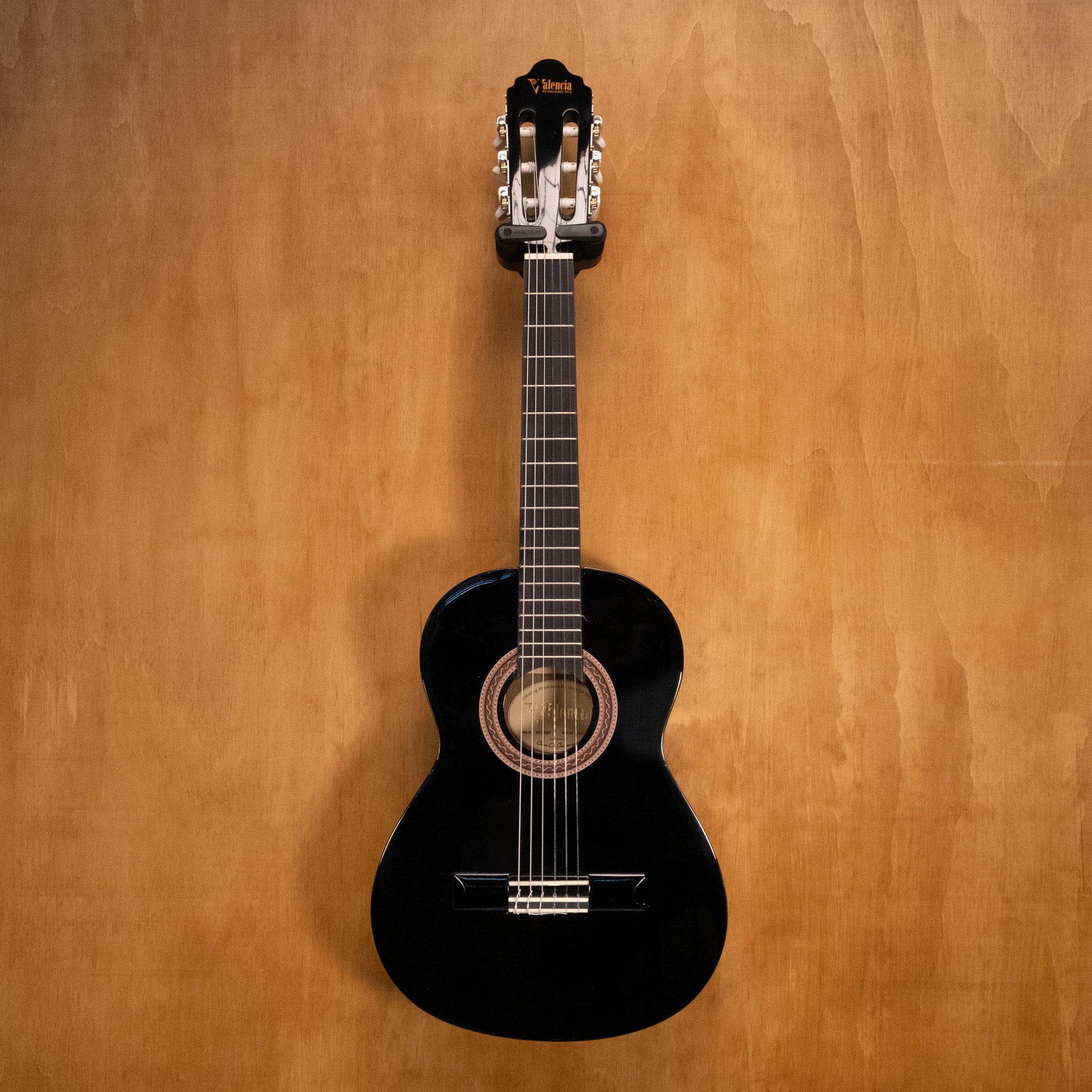 Preloved Valencia VC102 1/2 classical guitar in black with nylon strings, wood body, and standard tuning, resting on a stand.