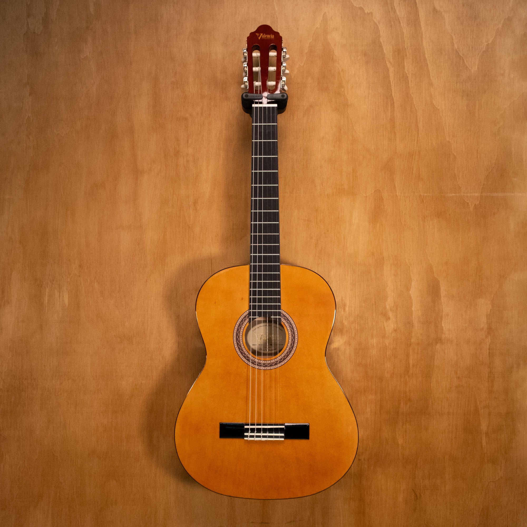 Valencia VC104 4/4 classical guitar in natural finish, showing the full body and neck of this nylon-string instrument.