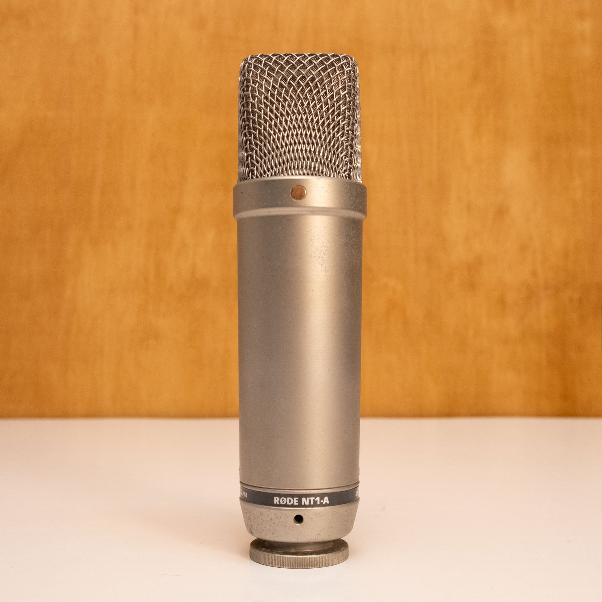 Rode NT1-A condenser studio microphone with silver finish, mounted on a stand, suitable for professional recording.