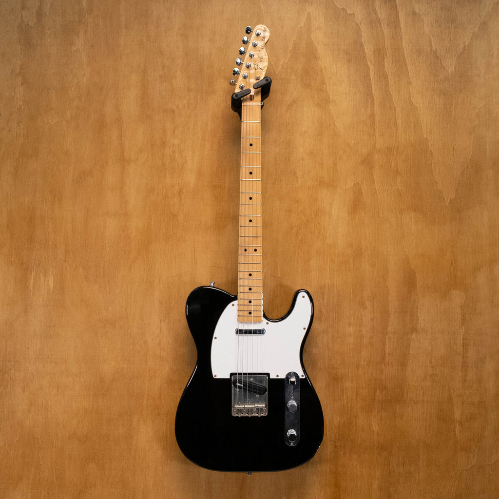 Fender '70s Telecaster TL71 electric guitar in black with maple neck, made in Japan, shown on a stand against a plain background.