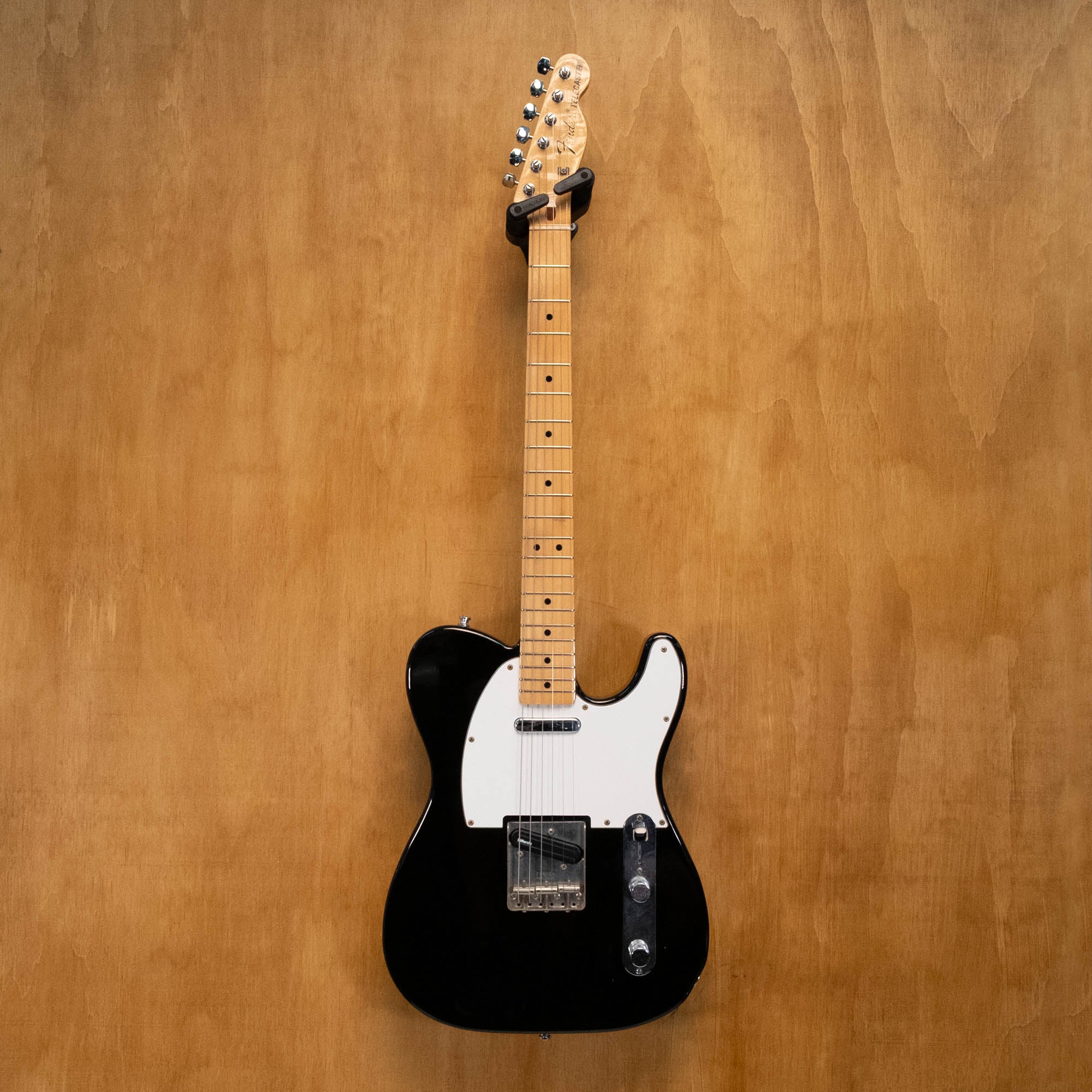 Fender '70s Telecaster TL71 electric guitar in black with maple neck, made in Japan, shown on a stand against a plain background.