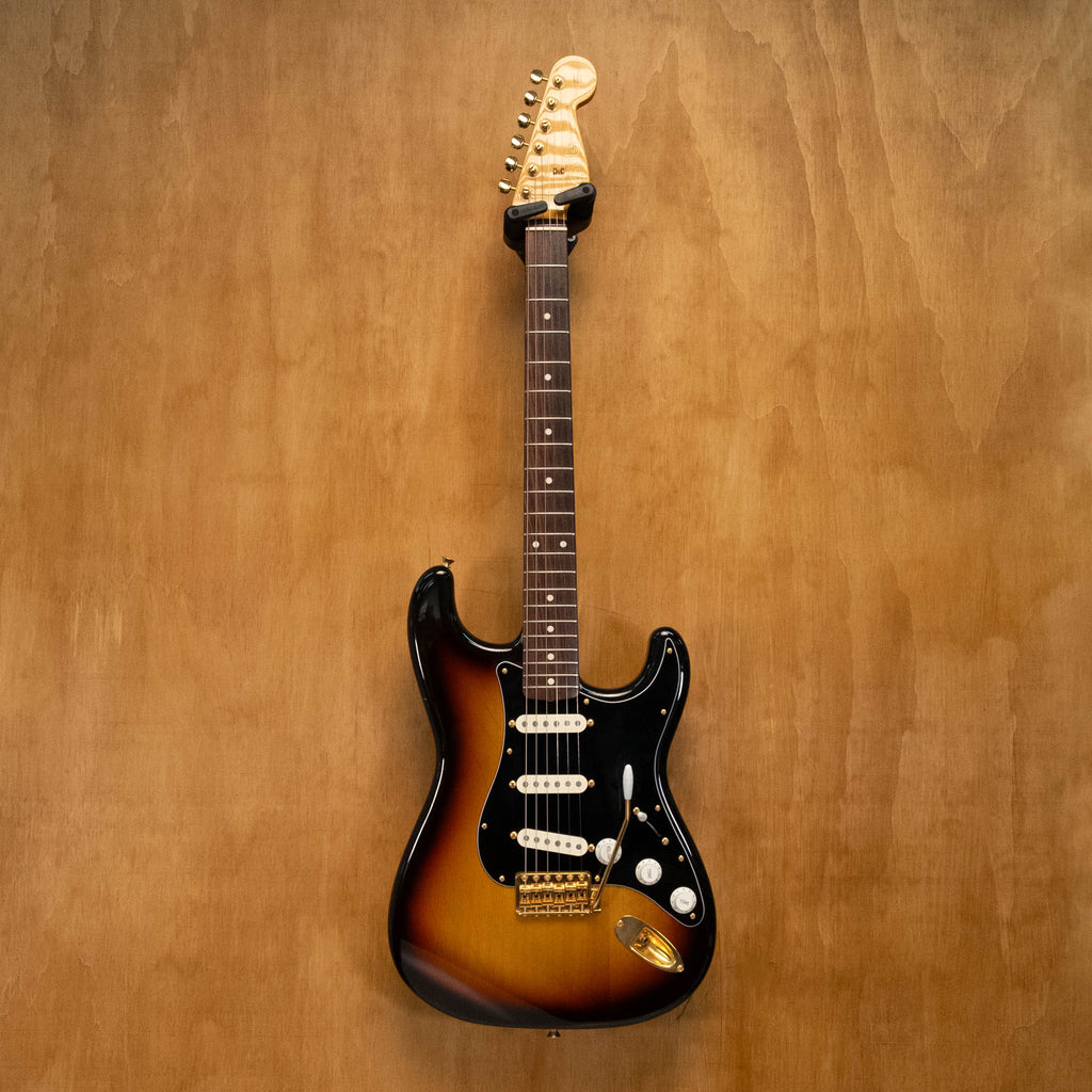 Fender '62 Stratocaster electric guitar in 3-tone sunburst with gold hardware, made in Japan, shown with body and neck details.