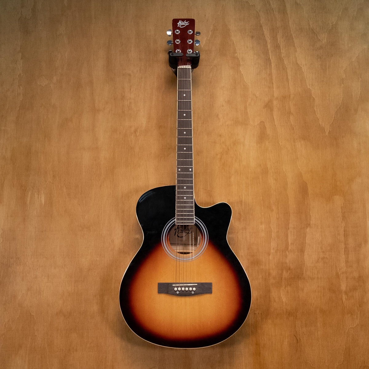 Huxley acoustic guitar in sunburst finish, showcasing its body, neck, and strings, on a plain background.