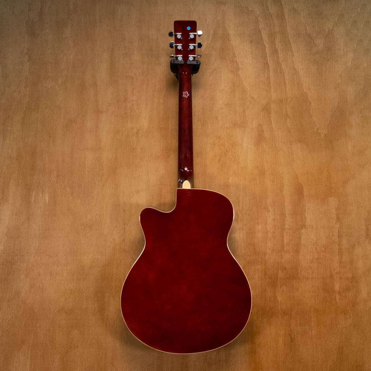 Huxley Sunburst acoustic guitar with a natural wood finish, showcasing its body, strings, and tuning pegs.