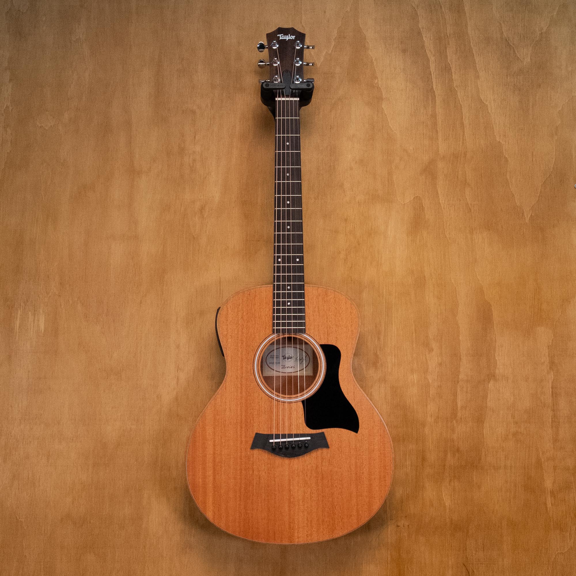 Taylor GS Mini-E Mahogany acoustic guitar, preowned, with a close-up view of the wood grain and guitar body.