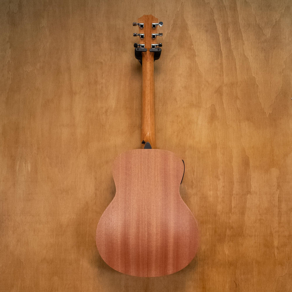 Taylor GS Mini-E Mahogany acoustic guitar, preowned, with a compact body and natural wood finish, displayed on a stand.