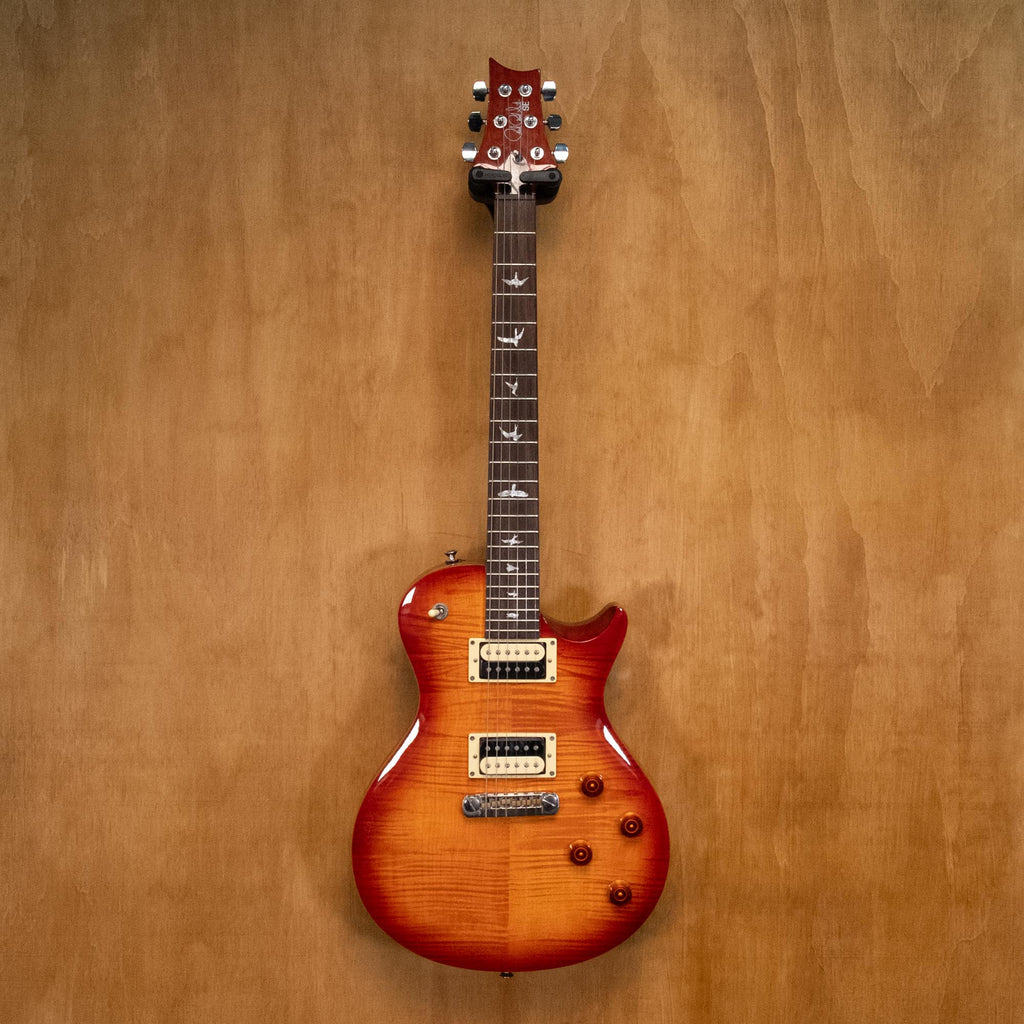 PRS SE 245 single cutaway electric guitar in vintage sunburst finish, featuring a sleek body and dual humbucker pickups.