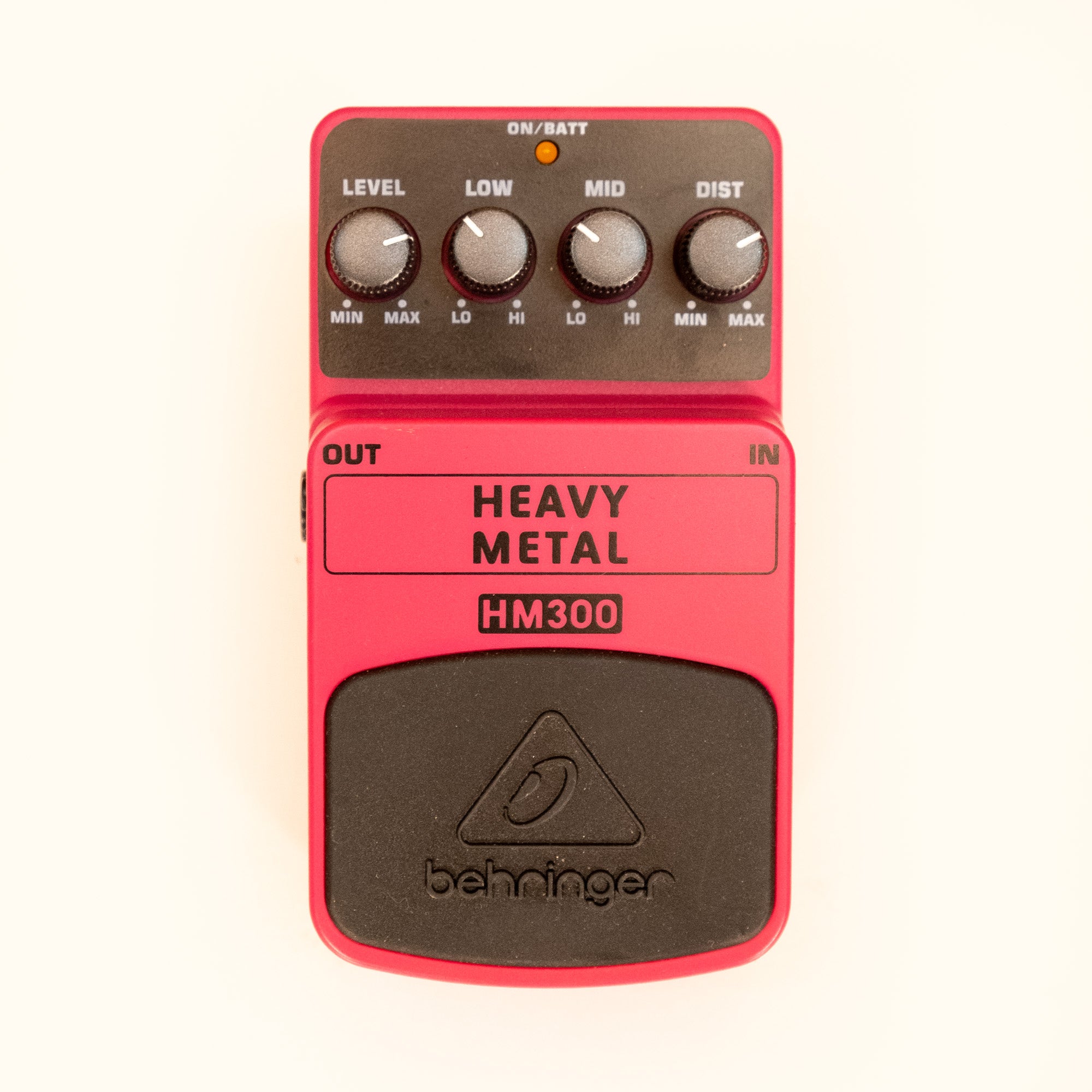 Behringer HM300 Heavy Metal Distortion Guitar Effects Pedal on a pedalboard, showing its metal housing and control knobs.
