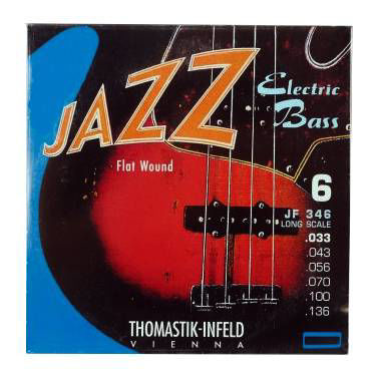 Thomastik JF346 flat wound electric bass guitar string set with six strings, size 33-136, arranged on a display.