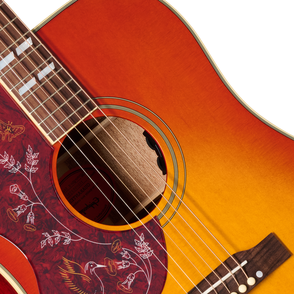 Left-handed Epiphone Hummingbird Standard acoustic guitar in cherry sunburst finish, showcasing its body and distinctive design.