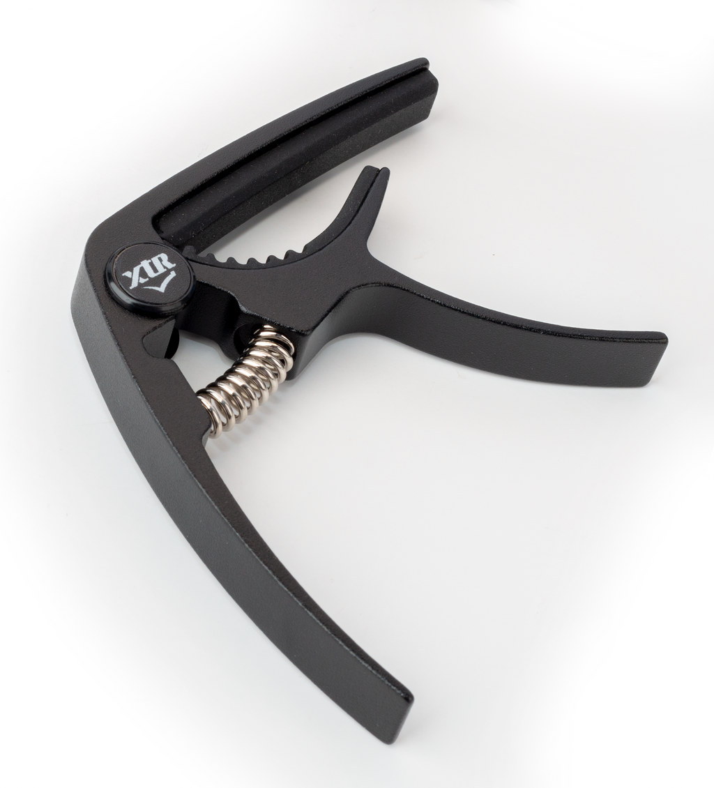 Black XTR GPX4CB trigger-style guitar capo on a guitar neck, designed for easy one-handed use and secure string pressure.
