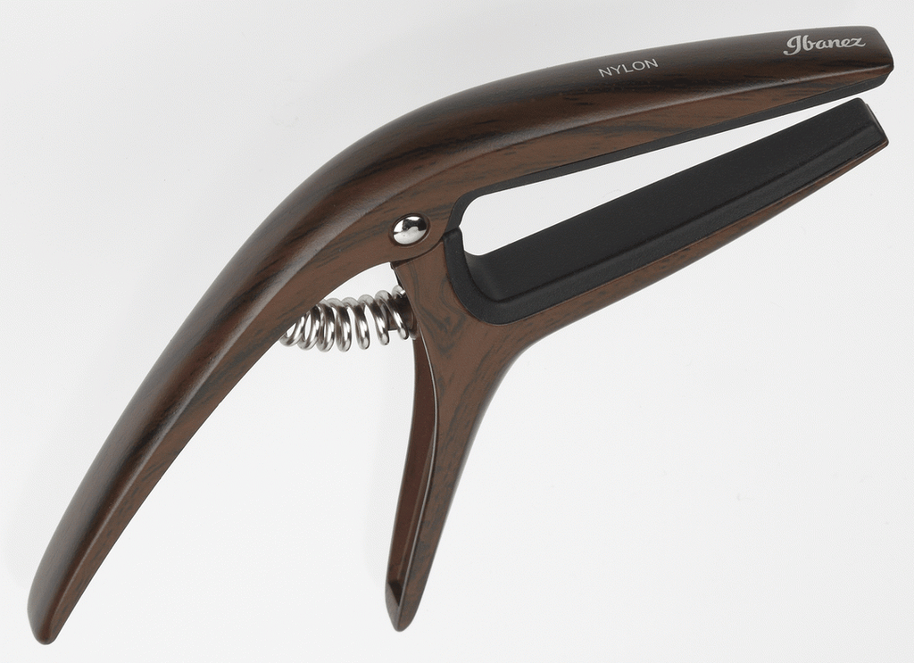 Ibanez ICGC10W wooden finish universal guitar capo attached to a guitar neck, showcasing its smooth wooden surface and adjustable clamp.