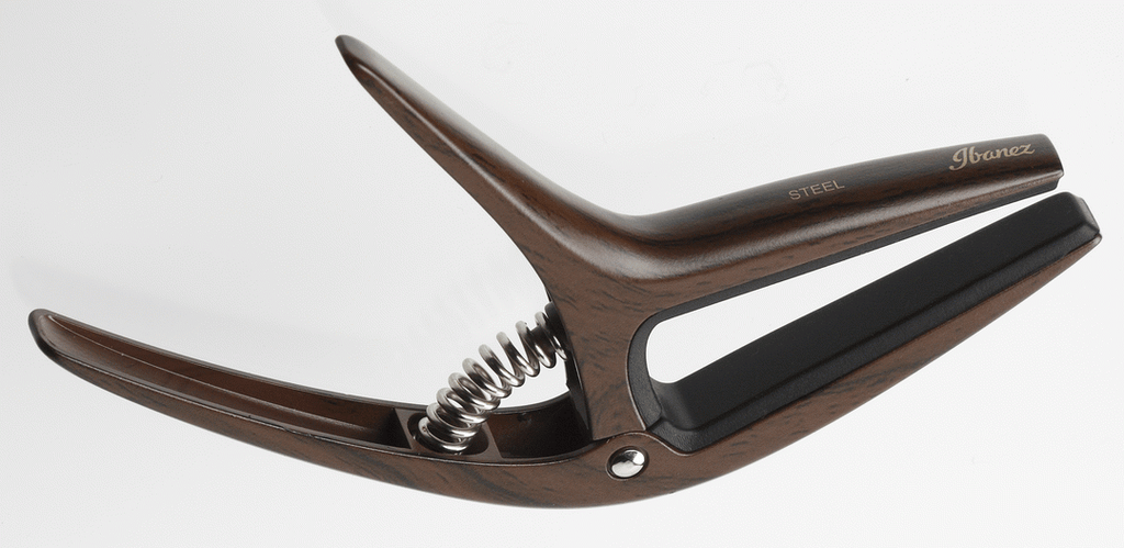 Ibanez ICGC10W wooden finish universal guitar capo clipped on guitar neck, showcasing its smooth wooden design and adjustable clamp.
