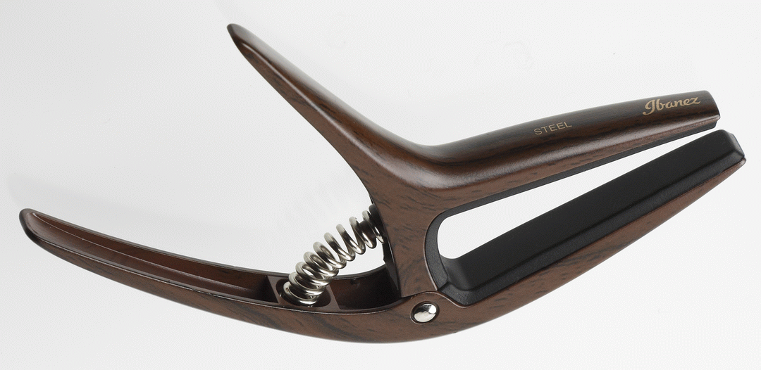 Ibanez ICGC10W wooden finish universal guitar capo clipped on guitar neck, showcasing its smooth wooden design and adjustable clamp.