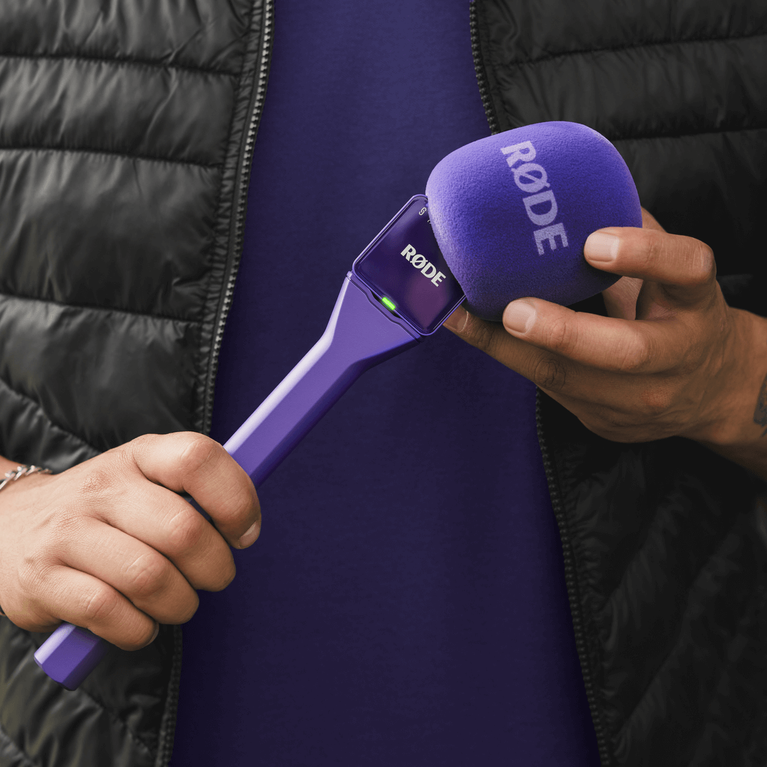 Purple Rode Interview GO handheld adaptor for Wireless GO mic system, shown with microphone attachment and connecting parts.