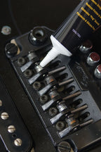 Music Nomad MN106 Tune It lubricant bottle for guitar tuning and maintenance, showing the product label and applicator tip.