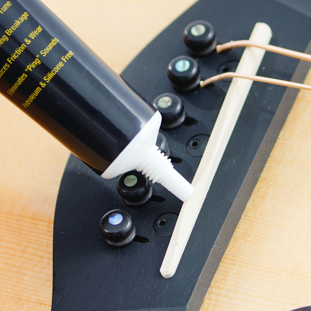 Music Nomad MN106 Tune It Lubricant for guitar tuning and maintenance, shown in a small bottle with a dropper applicator.