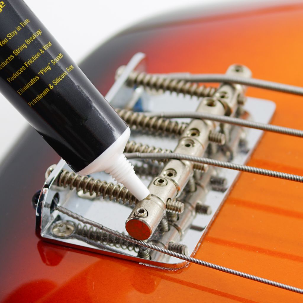 Music Nomad MN106 Tune It lubricant for guitar tuning pegs and hardware, shown in a small bottle with label.