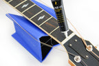 Music Nomad MN106 Tune It Lubricant for guitar tuning pegs and bridges, in a small bottle with a white cap.