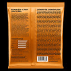Ernie Ball 2833 Hybrid Slinky Nickel Wound Electric Bass Strings laid out on a surface, showing the packaging and string details.