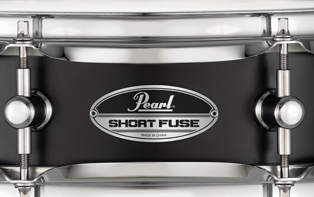 Pearl Pearl Snare Short Fuse 13x3.5 black steel snare drum with chrome hardware and drumheads, close-up view.