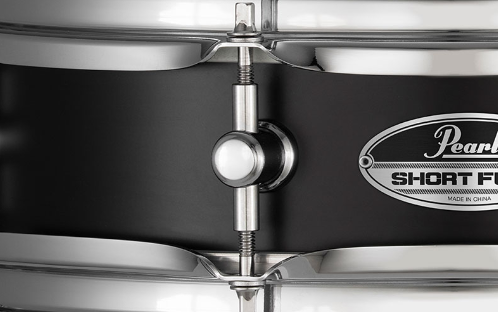 Pearl Pearl Snare Short Fuse 13x3.5 black steel snare drum with chrome hardware and drumsticks on a stand.