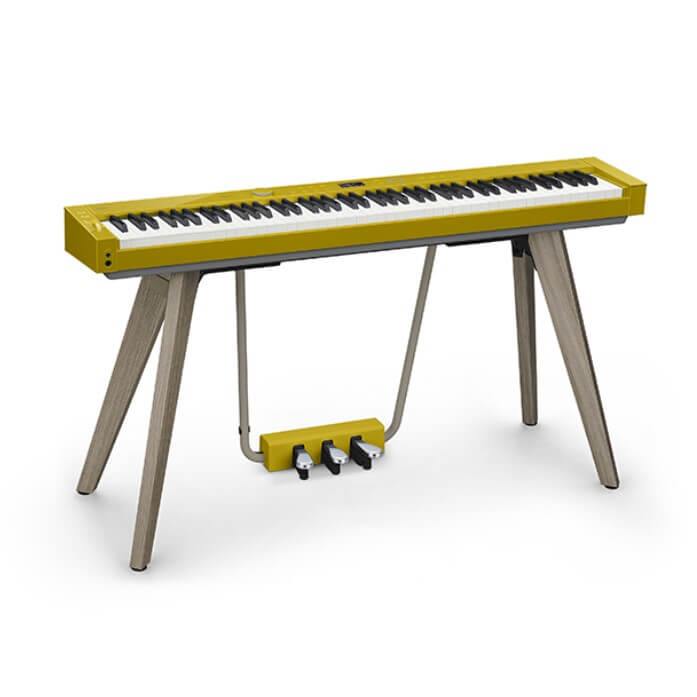 Casio Privia PX-S7000 portable digital piano with mustard and oak stand, showing the sleek black digital keyboard and stand.