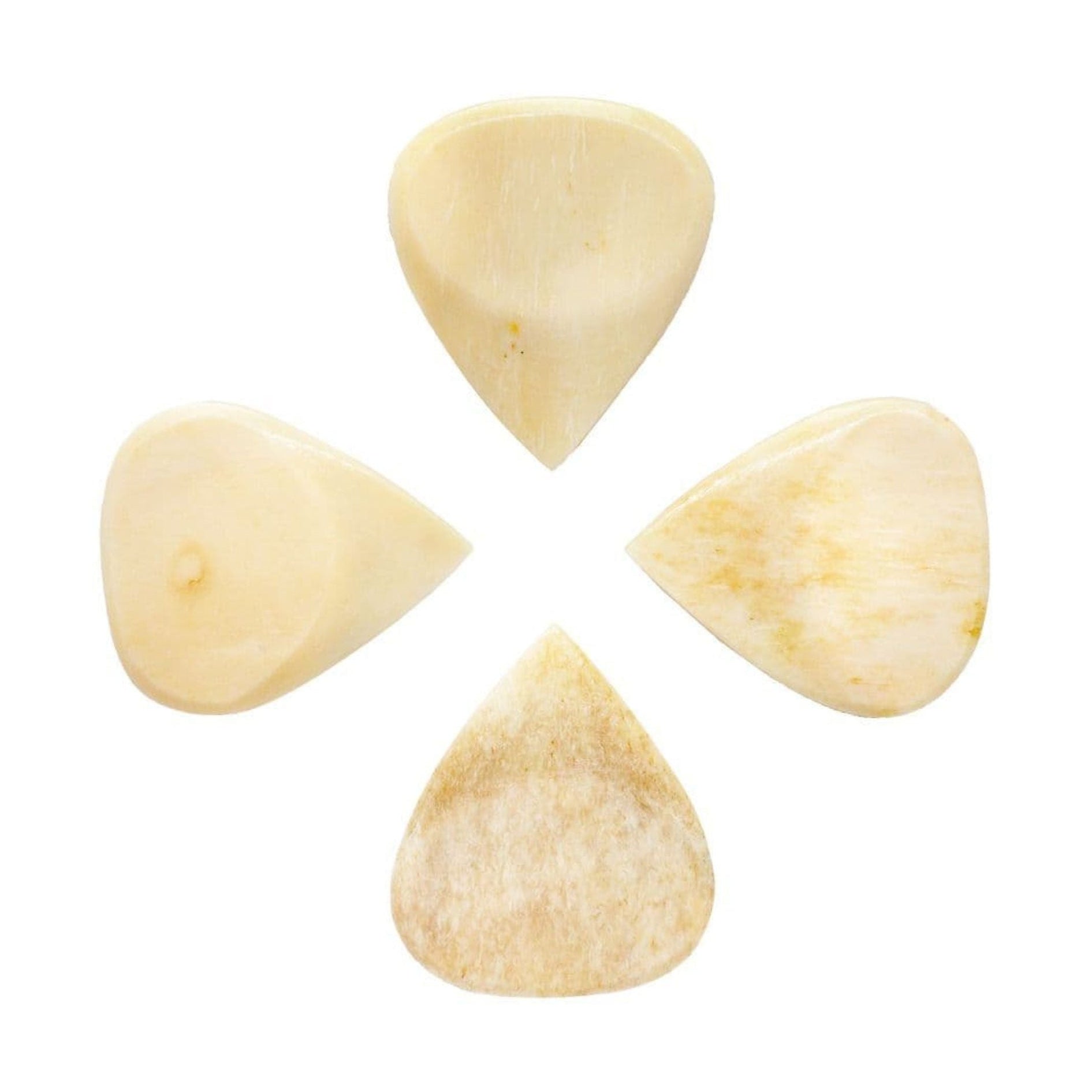 Set of four Timber Tones Bone Tones Fat Buffalo Bone Guitar Picks, showcasing natural bone material and pick shapes.