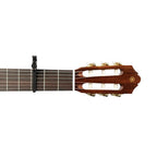 D'Addario Planet Waves PW-CP-13 Artist classical guitar capo in black resting on a wooden guitar neck.